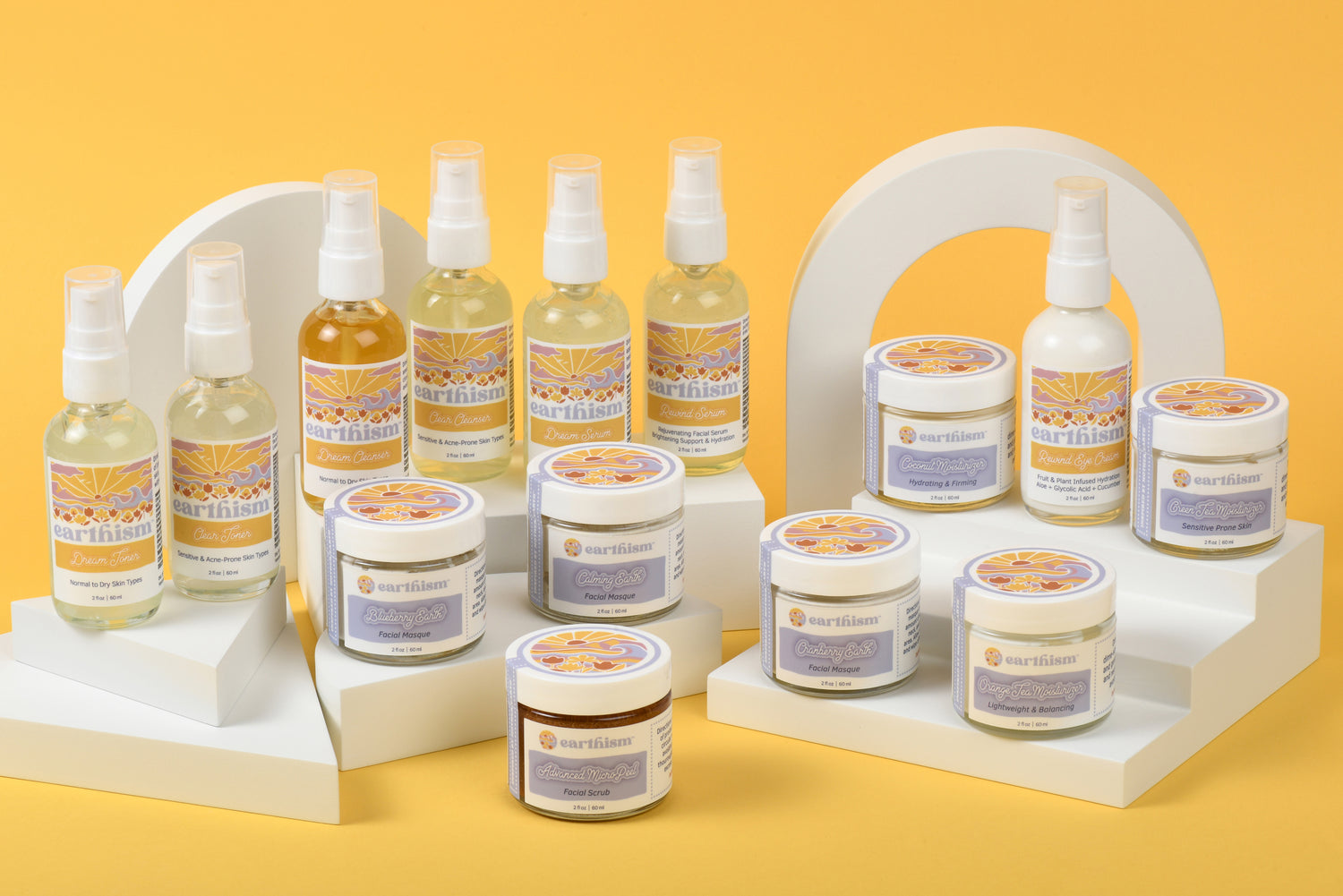 Earthism Skincare full line shown in image with white displays on a yellow background